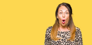 Leopar hayvan baskı elbisesi giyen güzel orta yaş kadın sürpriz ifade, korku ve heyecanlı yüz ile korkuyor ve şok.