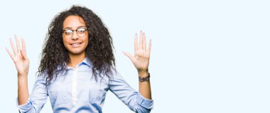 Kıvırcık saçlı Genç güzel iş kızı gösteren ve parmak sayısı dokuz ile işaret eden gözlük giyiyor emin ve mutlu gülümseyen iken.