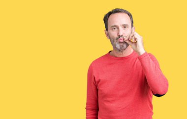 Yakışıklı Orta Çağ ağarmış yaşlı adam izole arka plan ağız üzerinde kış kazak giyiyor ve dudaklar parmaklar ile fermuar olarak kapatıldı. Gizli ve sessiz, tabu konuşan