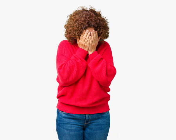 Beautiful middle ager senior woman red winter sweater over isolated background with sad expression covering face with hands while crying. Depression concept.