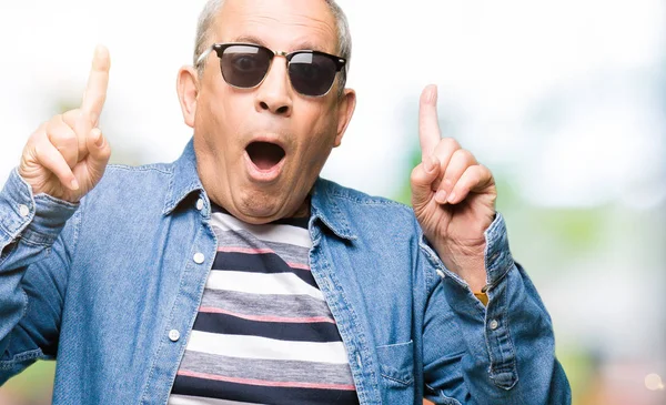 Handsome Senior Man Wearing Denim Jacket Sunglasses Amazed Surprised Looking — Stock Photo, Image