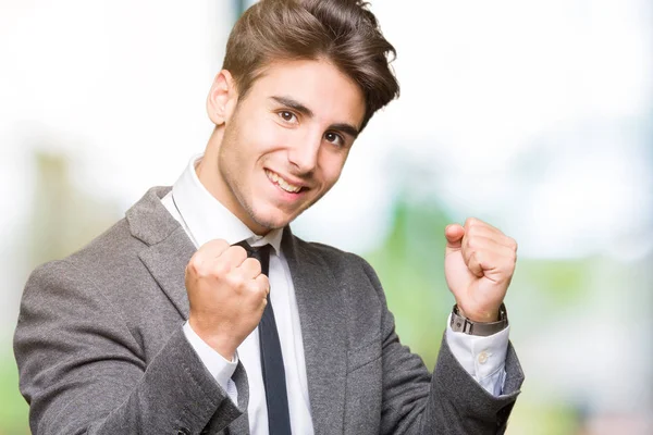 身に着けている若いビジネスマンのスーツし 笑顔と成功のために叫んで 非常に幸せと興奮の腕を上げ 勝者のジェスチャを行う分離の背景にネクタイします お祝いのコンセプト — ストック写真