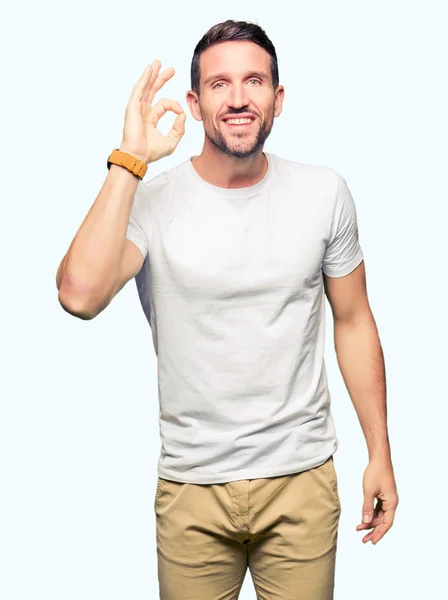 Hombre Guapo Vistiendo Casual Camiseta Blanca Sonriendo Positiva Haciendo Signo —  Fotos de Stock