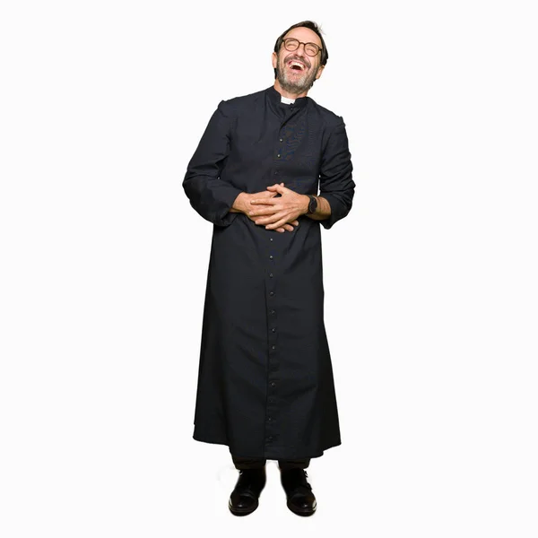 カトリックのローブを着た中年の司祭の男は笑って 面白いクレイジージョークので大声で笑う ハッピーな表情 — ストック写真