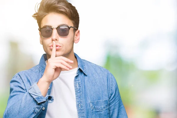 Jonge Knappe Man Dragen Van Een Zonnebril Geïsoleerde Achtergrond Vragen — Stockfoto