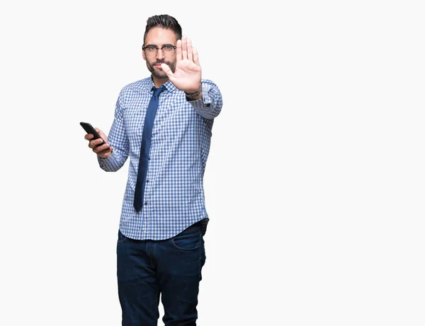 年轻商人使用智能手机在孤立的背景与打开的手做停止标志与认真和自信的表情 防御手势 — 图库照片