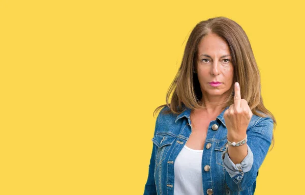 Beautiful middle age woman wearing casual denim jacket over isolated background Showing middle finger, impolite and rude fuck off expression