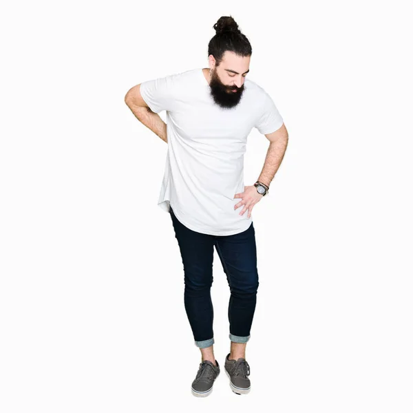 年轻的嬉皮士男子长头发和胡子穿着休闲的白色 T恤背痛 用手触摸背部 肌肉疼痛 — 图库照片