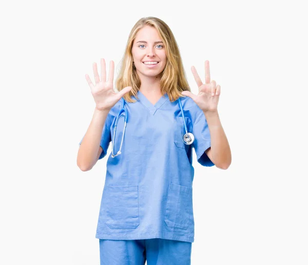 美丽的年轻医生妇女穿着医疗制服在孤立的背景显示和手指指向八 同时微笑着自信和快乐 — 图库照片