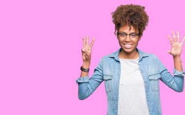 Güzel genç Afro-Amerikan kadın gözlük gösterilen ve parmakları ile işaret izole arka plan üzerinde kendinden emin ve mutlu gülümseyerek süre sekiz numara.