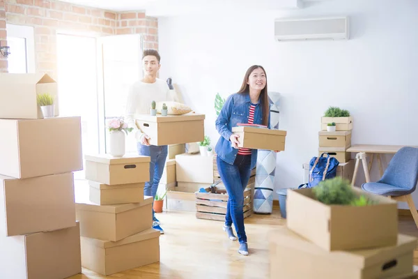 Beautiful young asian couple looking happy holding cardboard box