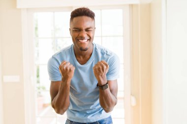 Afrika kökenli Amerikalı adam çok heyecanlı ve kutluyor başarı ve zafer, çığlık happpy gülümseyerek ve neşeli