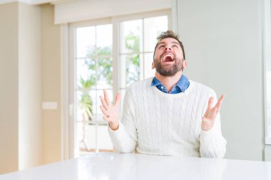 Yakışıklı adam rahat kazak giyen deli ve deli bağırarak ve agresif ifade ve kollar kaldırdı ile bağırıyor. Hayal kırıklığı kavramı.