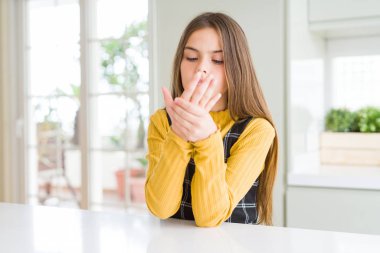 Young beautiful blonde kid girl wearing casual yellow sweater at home Suffering pain on hands and fingers, arthritis inflammation