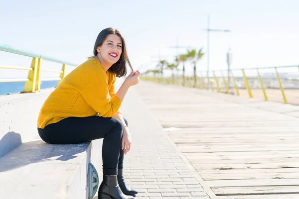 Mooie Jonge Vrouw Zittend Een Promenade Aan Zee Lacht Vrolijk — Stockfoto