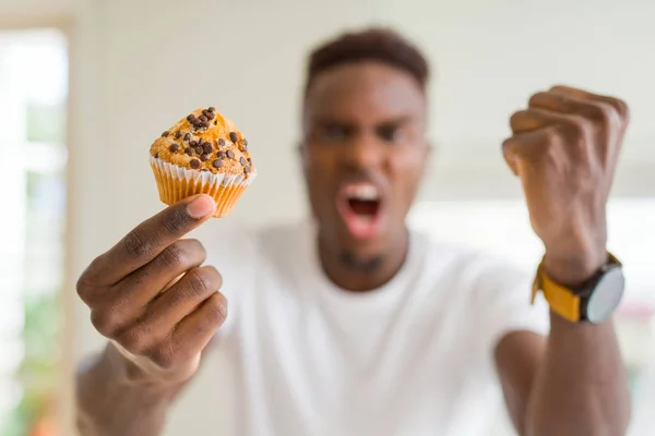 チョコレートチップを食べるアフリカ系アメリカ人の男性は 狂気と上げられた手で叫んで怒りとイライラした怒りとイライラした 怒りの概念 — ストック写真