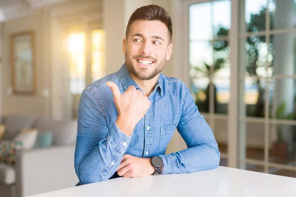 Joven Hombre Guapo Casa Señalando Mostrando Con Pulgar Hacia Lado —  Fotos de Stock