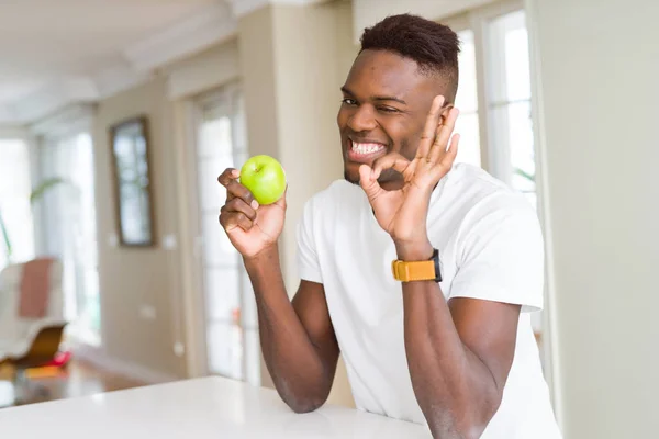 Mladý Africký Američan Jíst Čerstvé Zelené Jablko Dělá Znamení Prsty — Stock fotografie
