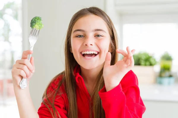 Όμορφο Νεαρό Κορίτσι Που Τρώει Φρέσκο Μπρόκολο Πολύ Χαρούμενο Δείχνοντας — Φωτογραφία Αρχείου