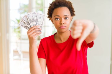 Kızgın yüz ile elli dolar banka banknotları tutan genç Afrikalı Amerikalı kadın, başparmak aşağı, ret kavramı ile sevmediğimi gösteren negatif işareti