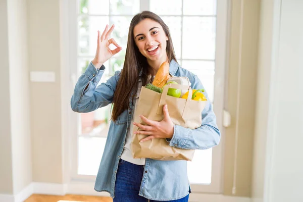 美丽的年轻女子拿着纸袋充满了健康的杂货做好标志用手指 优秀的符号 — 图库照片