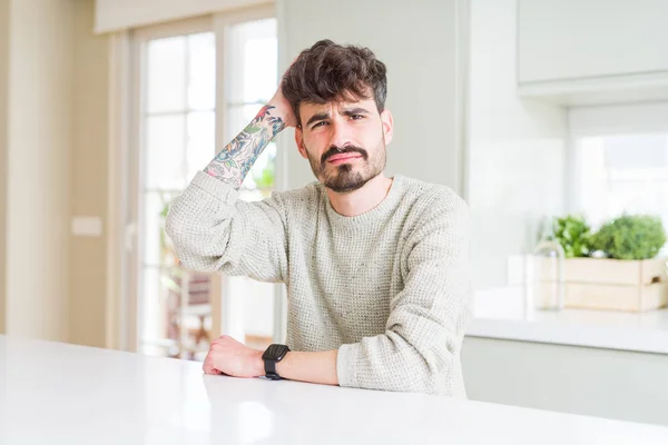 Hombre Joven Con Suéter Casual Sentado Mesa Blanca Confundir Preguntarse — Foto de Stock