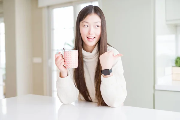 Красивая Азиатка Пьет Чашку Кофе Указывая Показывая Пальцем Вверх Сторону — стоковое фото