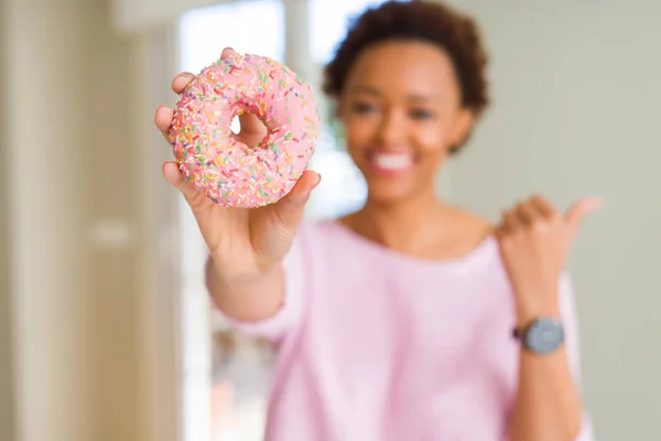 Joven Afroamericana Americana Comiendo Rosado Azúcar Donut Apuntando Mostrando Con —  Fotos de Stock