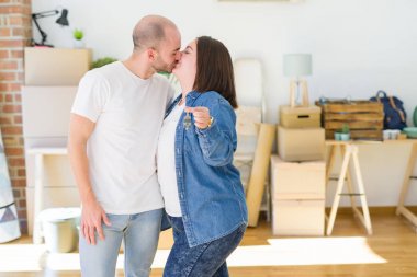 Genç çift çok mutlu yeni ev, hareket ve yeni apartmet kavramı satın anahtarları gösteren gülümseyen