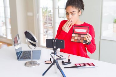 Genç afro-amerikan influencer kadın kayıt hata için utanç ile şok el ile öğretici kapak ağız makyaj, korku ifadesi, sessizlik, gizli kavram korkmuş