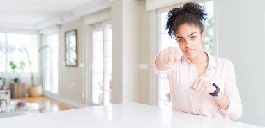 Wide angle of beautiful african american woman with afro hair Punching fist to fight, aggressive and angry attack, threat and violence
