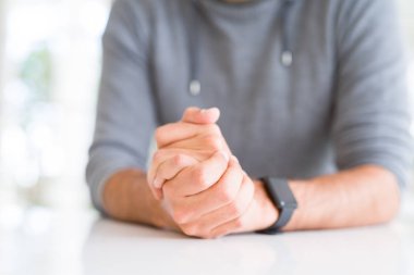 Beyaz masa üzerinde çapraz eller ile adam yakın 