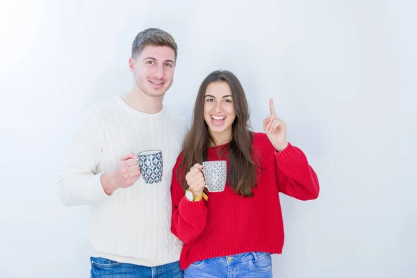 Casal Jovem Bonito Sobre Fundo Isolado Branco Bebendo Uma Xícara — Fotografia de Stock