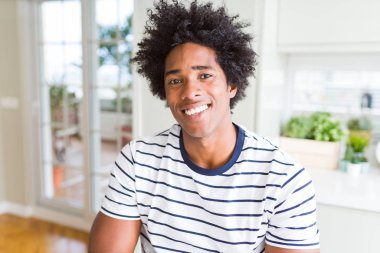 Afro-Amerikan adam yüzünde mutlu ve serin bir gülümseme ile çizgili t-shirt giyiyor. Şanslı kişi.