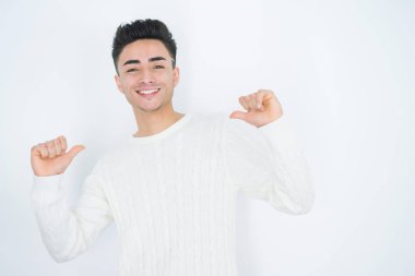 Beyaz izole arka plan üzerinde Yakışıklı genç adam yüzünde gülümseme ile emin görünümlü, parmakları gururlu ve mutlu kendini işaret.