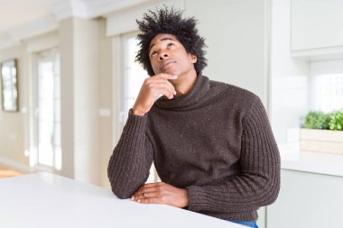 Afrikalı-Amerikalı giyen kış kazak çene düşünme hakkında soru, dalgın ifade üzerine el ile dostum. Düşünceli yüzüyle gülümsüyor. Şüphe kavramı.