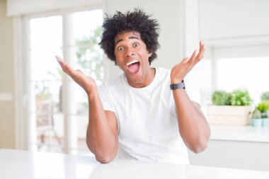 Beyaz bir tişört giyen genç Afro-Amerikalı adam evde oturmuş çılgınlığı kutluyor ve başarıya hayret içinde kollarını kaldırıp heyecanla haykırıyor. Kazanan konsept