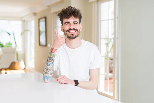 Joven Con Una Camiseta Casual Sentado Una Mesa Blanca Haciendo — Foto de Stock