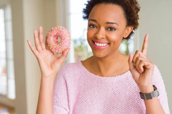 Νεαρή Αφροαμερικανή Που Τρώει Ροζ Ντόνατ Ζάχαρη Έκπληκτη Μια Ιδέα — Φωτογραφία Αρχείου