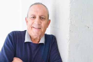 Neşeli, mutlu ve pozitif eğilimli çapraz kolları olan beyaz arka plan üzerinde gülümseyen yakışıklı orta yaş komuta sizde