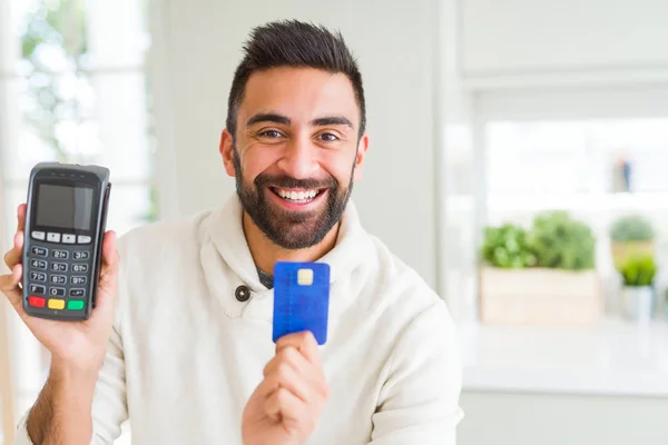 Hombre de negocios sonriendo y sosteniendo punto de venta terminal y cred —  Fotos de Stock