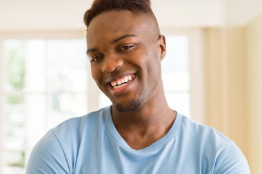 Gülümseyen yüzünde kocaman bir gülümseme ile neşeli Afrika yakışıklı genç