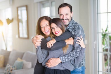 Güzel aile birlikte. Anne, baba ve kızı gülümseyen ve evde sevgi ile sarılma.