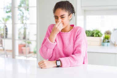 Afro saçlı güzel afro-amerikan kadın rahat pembe kazak giyen bir şey kokulu ve, dayanılmaz koku, burun parmakları ile nefes tutarak. Kötü kokular kavramı.