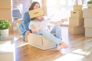 Komik ve çılgın çift bir araba olarak bir cardboad kutusu sürme eğlenceli sahip, mutlu gülümseyen ve yeni evde gülüyorsun