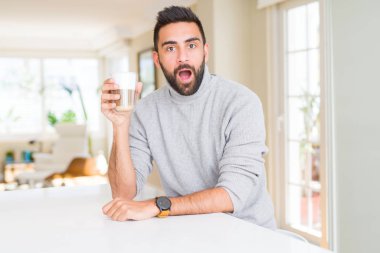 Yakışıklı İspanyol adam sürpriz bir yüz ile şok içinde korkmuş bir fincan kahve içme, korku ifade ile korkmuş ve heyecanlı