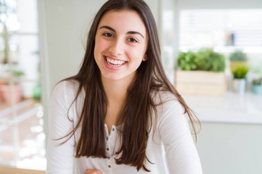 Güzel genç esmer kadın yüz gösteren büyük bir gülümseme ile kamera bakıyor neşeli gülümseyen