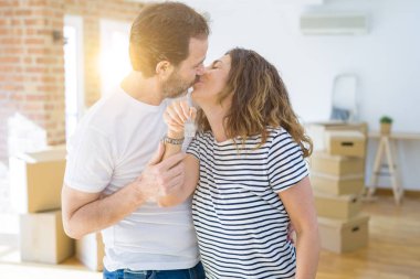 Orta yaş Senior romantik çift Holding ve yeni bir eve taşımak için mutlu gülümseyen ev anahtarlarını gösteren