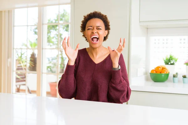 年轻美丽的非洲裔美国女人在家里疯狂和疯狂的喊话和大喊大叫 积极的表情和手臂抬起来 挫折的概念 — 图库照片