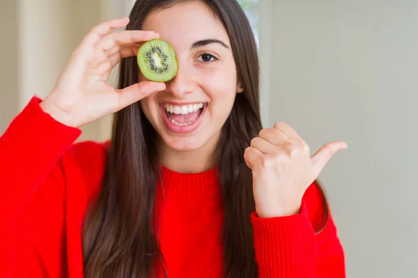 Gyönyörű Fiatal Eszik Félig Friss Zöld Kiwi Mutatva Mutatja Hüvelykujjával — Stock Fotó